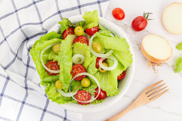 Fresh and healthy salad with lettuce, onion, cherry tomato and olives in a bowl. Mediterranean food