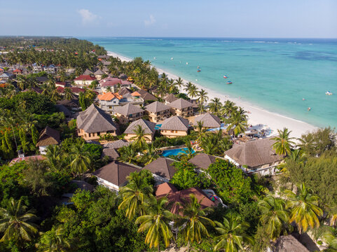 Aerial shot of a luxury hotel on a Beach first line with Palm Trees Garden at evening time in Paje village, Zanzibar, Tanzania