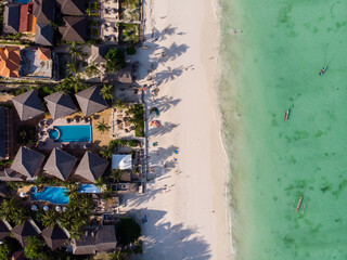 Aerial shot of a luxury hotel on a Beach first line with Palm Trees Garden at evening time in Paje village, Zanzibar, Tanzania