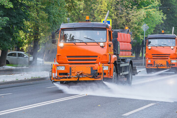 Cleaning machines washe the city street early in the morning.