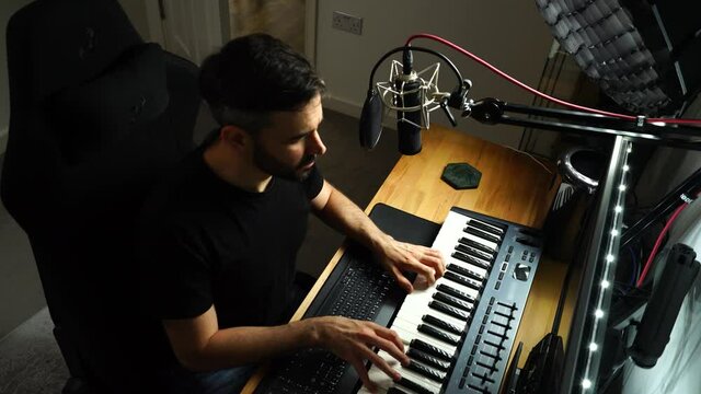 Musician Composes and records music. Playing piano in home sound studio. Medium Top shot