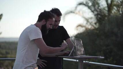 Two colleagues working together on project helping each other out on notebook