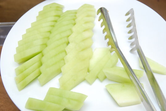 fresh melon slices served on a white plate