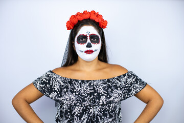 Woman wearing day of the dead costume over isolated white background skeptic and nervous,...