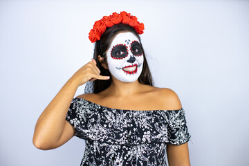 Woman wearing day of the dead costume over isolated white background smiling doing phone gesture with hand and fingers like talking on the telephone