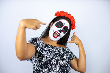 Woman wearing day of the dead costume over isolated white background doing the “call me” gesture with her hands.