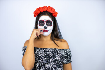 Woman wearing day of the dead costume over isolated white background mouth and lips shut as zip...