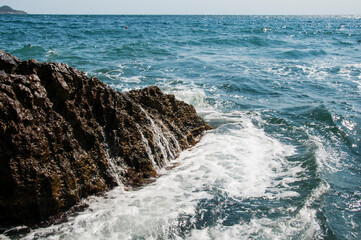 Sea surf. Waves breaking on a rock in the water. Sea foam.