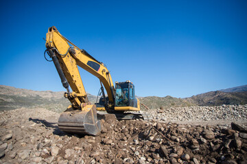 Close up wide angle image of an excavator machine working on an agricultural farm