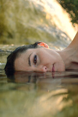 close-up of woman lying on her side with half face in the water