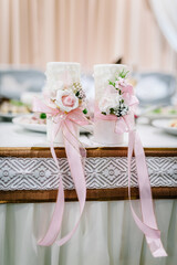 The candles with white flowers on wedding party. Close up. Wedding decor.