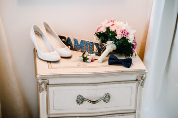 White women's shoes, bride's bouquet, groom's boutonniere, bow - tie. Wedding accessories bride and...