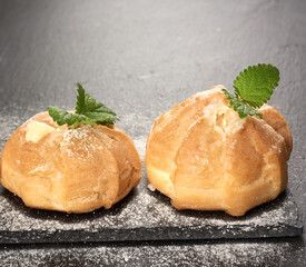 baked custard eclairs and sprinkled with powdered sugar and decorated with a mint leaf