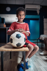 A little soccer player posing with the ball before the match