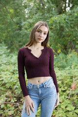 Portrait of a beautiful brunette outdoors on a green forest background.