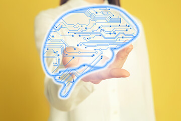 Woman demonstrating digital image of brain on yellow background, closeup. Machine learning concept