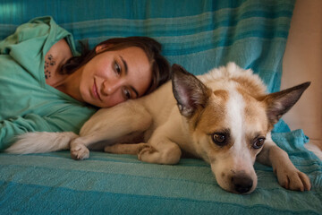 Cute dog and its owner lying on the sofa and relaxing