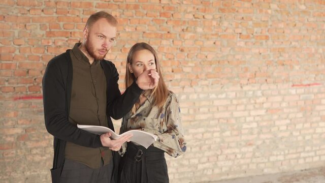 Potential Buyers of Real Estate Property Caucasian Couple Male and Female Looking At Documentation Talking and Looking Front. Light Camera Movement