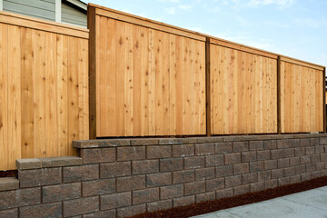 Wood Fence on Stone Retaining Wall on Side of Home - 380651067