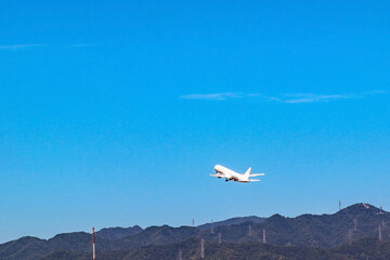 青空へ向かって飛び立つ飛行機