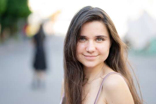 Portrait of a young woman with a lovely smile in a velor summer dress.