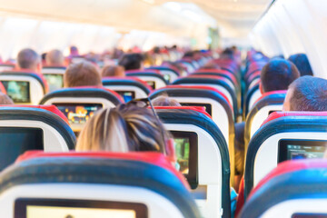 Fototapeta premium People flying sitting in plane interior with multimedia screens