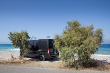 Black campingcar wildcamping on desolate beach in Greece
