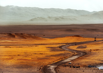 Wide overview deserted desert landscape with red stones and windy road in the middel, in Paracas, Peru