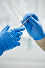 Close-up of the hands of a dentist and nurse surgeon over an operating room during a dental implant...
