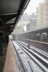 gros flocons de neige tombant sur les rails d'une gare vus en perspective en ville 