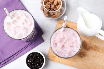 Bubble milk tea and bowl with tapioca balls on light grey marble table, flat lay