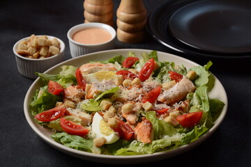 Caesar Salad with grilled chicken, Cheese and Croutons with lettuce, on plate.  Grilled chicken breasts and fresh vegetables in plate. 