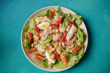 Caesar Salad with grilled chicken, Cheese and Croutons with lettuce, on plate.  Grilled chicken breasts and fresh vegetables in plate. 