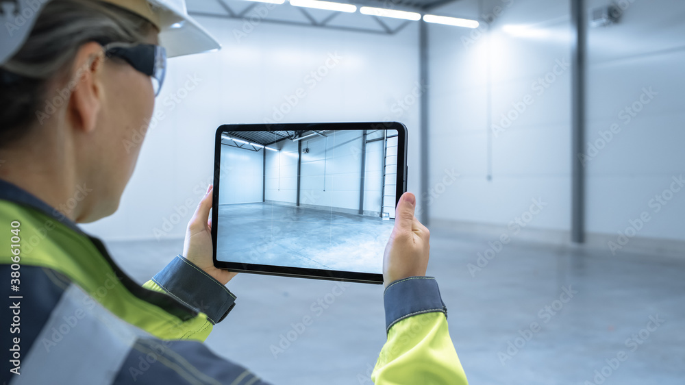 Poster Industry 4.0 Modern Factory: Female Engineer Uses Digital Tablet Computer with Augmented Reality Software Visualizing of Manufacturing Plant Room Mapping, Factory Layout. Concept Shot Suitable for AR.