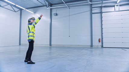 Industry 4.0 Modern Factory: Female Engineer Wearing Augmented Reality Headset Uses Mixed Reality Software and Gestures for Mapping Manufacturing Plant Floor for Future Machinery, Factory Floor Layout