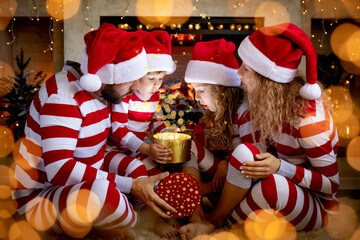 Happy family with children opening Christmas gift