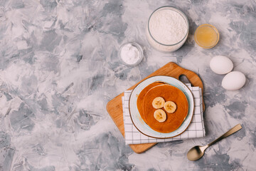 pancakes, eggs, honey, flour, soda on a gray background
