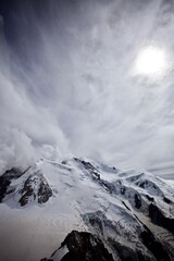 Mont Blanc Covered with snow and clouds. Single mountain peak. Snowy mountain peak. White mountain top on a cloudy day. Snow-covered white mountain peak. Mountains landscape. Climbing mountains.