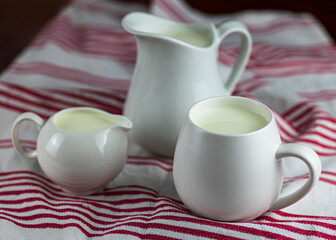 milk jugs on kitchen table with tea towel