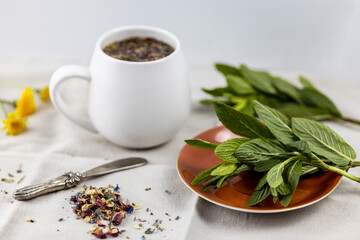 tea cup with rose petals and mint leaves