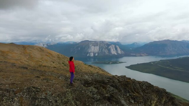 Adventurous Girl Hiking up Nares Mountain during a cloudy and sunny evening. Taken in Carcross near Whitehorse, Yukon, Canada.