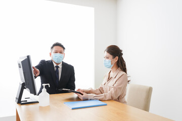 感染症対策をしてオフィスで働くビジネスパーソン