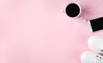 Sports flat lay with coffee, white sneakers, smartphone and earphones on pink background. Fitness concept. Concept healthy lifestyle. Top view. Copy space. Banner.