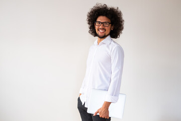 Latin american man, smiling expression, holding a laptop