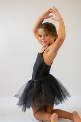 Cute adorable ballerina little girl in black tutu dance practices ballet dancing