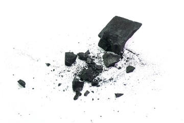Pile of natural broken black activated charcoal granules and powder on white background.