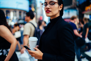 Young woman with cellphone and coffee in downtown