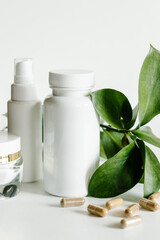 Herb capsules and white bottles, healthcare and beauty concept. 