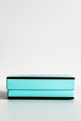 Decorative black and turquoise gift box with no bow on white background. Minimal festive concept. 