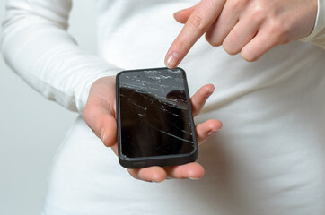 Close up of woman holding broken mobile phone